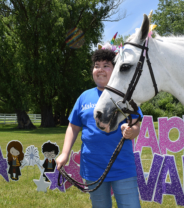 Valentina smiling with a unicorn