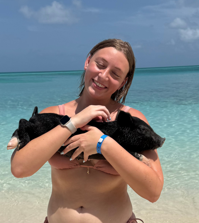 Briana holding a pig on her wish trip to The Bahamas to swim with pigs