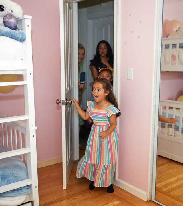 Emma on her wish day, jumping for joy as she sees her new bedroom for the first time. 