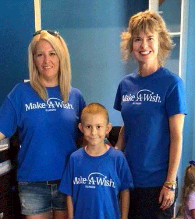 Beth standing next to another volunteer and wish kid