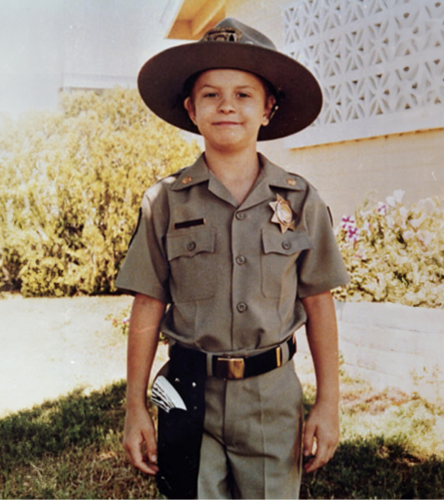 Wish kid Chris in a police uniform
