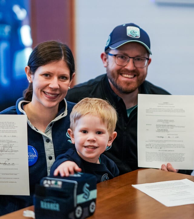 Wish kid Caleb and his parents holding the Kraken Contract