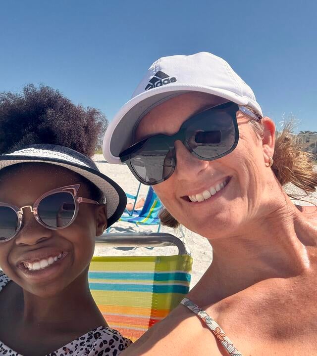 Chantelle and her daughter at the beach in sun hats