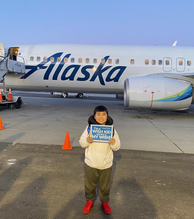 Wish kid in front of Alaska Airplane