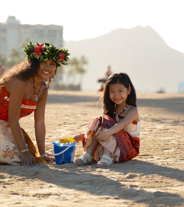 Avery sitting in the sand next to an Island Princess