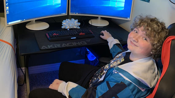 Matthew, 14, sits in front of his new gaming computer.
