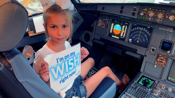 Shyla sits in the cockpit of the plane, ready to take off for her wish. 
