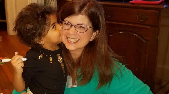 Wish kid Abrielle gives her volunteer, Robin, a smooch.