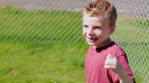 Wish kid Ace is all smiles in front of his new fence