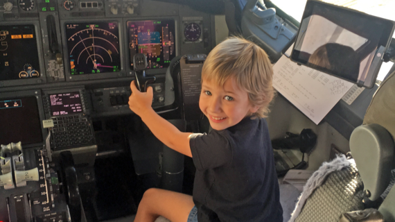 Wish Kid Avery in the cockpit of a plane behind the wheel
