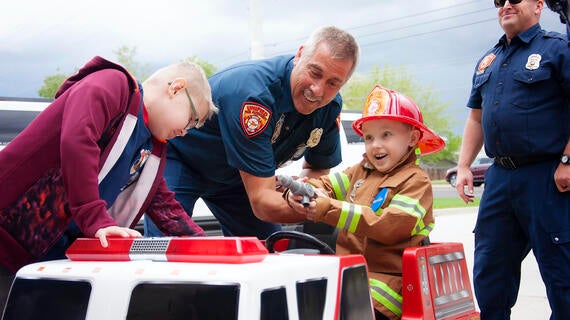 Eli surrounded by firefighter