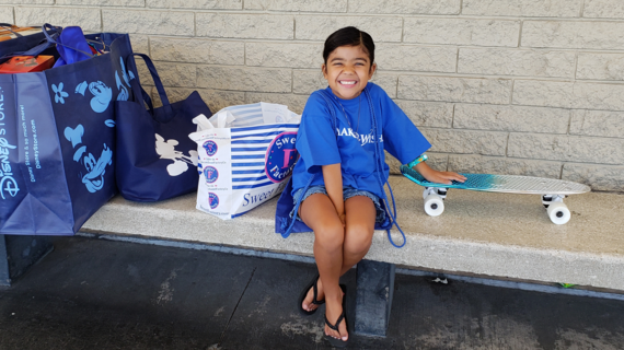 Wish Kid Lyric poses with her score from her shopping spree wish