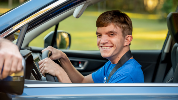 Wish kid Colton smiles behind the wheel of a Subaru Forester