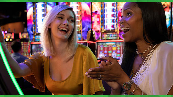 Two women play games and laugh at the Harrington Casino