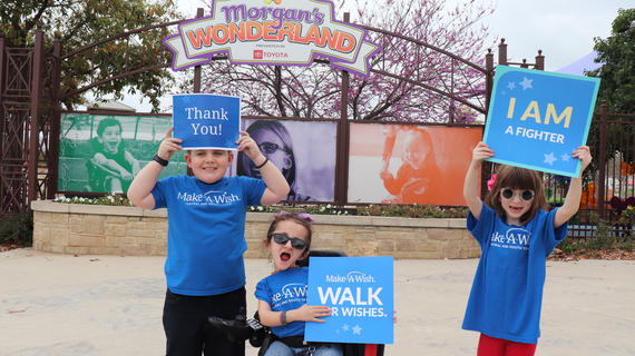 Wish Ambassadors Mason, Sammi, and Mabel holding signs for our Walk for Wishes.