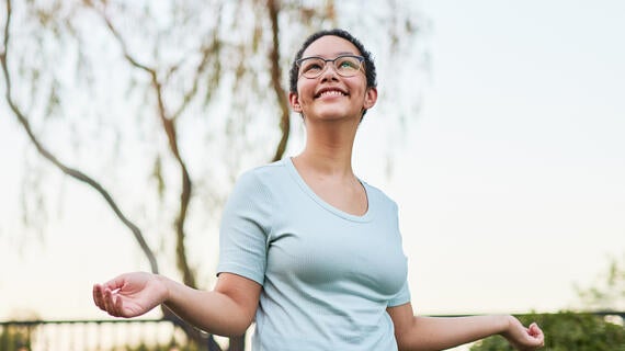 Wish kid Kylie looks up joyfully at the sky while twirling in her new backyard
