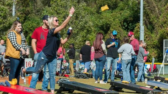 Woman playing corn hole at Pitchin for Wishes Cornhole Tournament