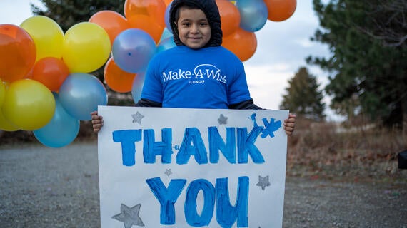 Wish child Sebastian holding up a thank you sign