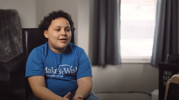 Wish child RJ smiling and wearing his blue Make-A-Wish t-shirt