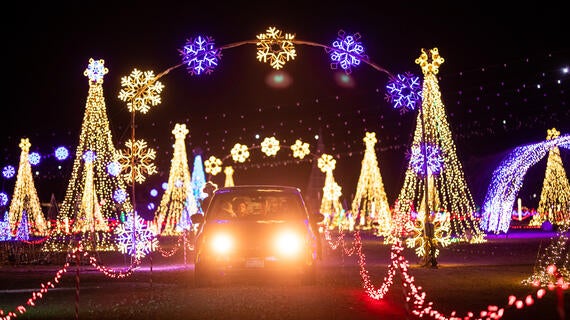 car driving through festive holiday lights
