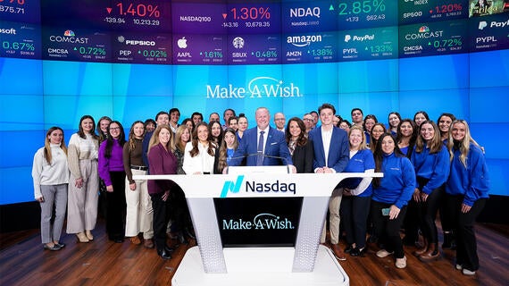 Make-A-Wish representatives stand at Nasdaq desk after bell ringing ceremony