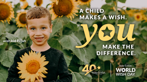 wish kid Elijah standing in a sunflower field holding a sunflower