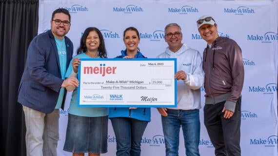 group on stage holding giant check