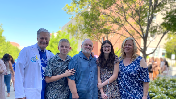 Addison takes a photo alongside her family, and Doctor Jolly is on the far left.
