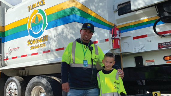 Carter and his Garbage Collector partner & Wish Granter from Turlock Scavenger pose in front of the truck that they rode around in for the day.