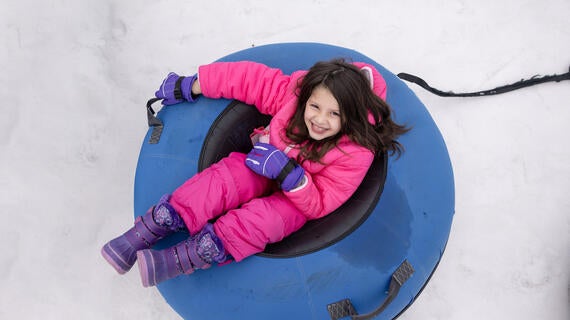 Wish kid Rivkah in an inner tube in the snow