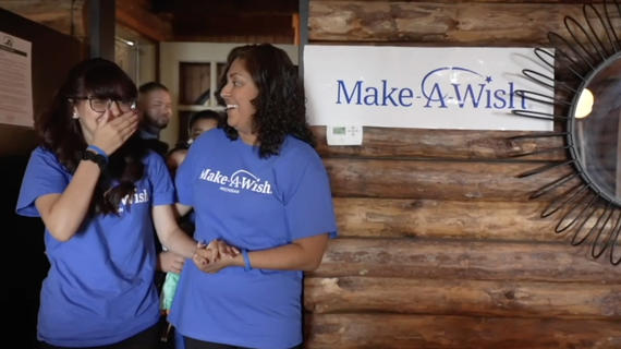 girl and mom wearing Make-A-Wish blue tshirts being surprised at wish
