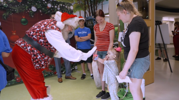 Santa giving high five to child at party