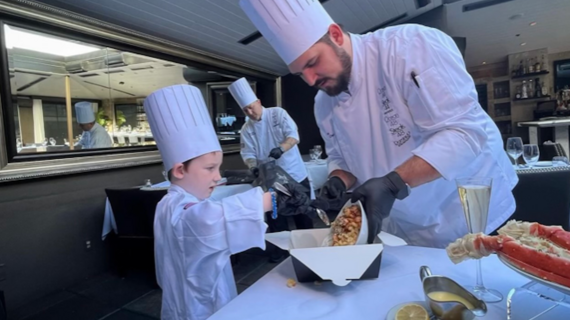 Wish kid Cooper helps the chef at Dominick's Steakhouse