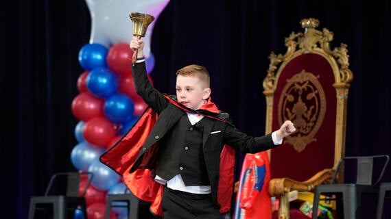 Wish kid ringing a bell running across the stage