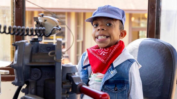 Wish kid Hazael in conductor's seat of a train