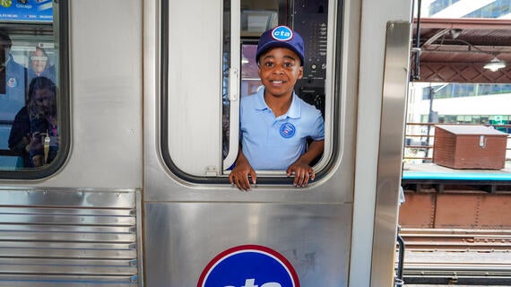 Wish kid Idris standing in window of CTA train looking at the camera