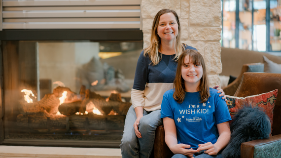 Wish Mom Jennifer and Wish Alumni Sadie sitting in front of a fireplace