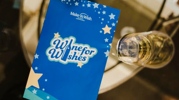 Wine for Wishes program on glass table 