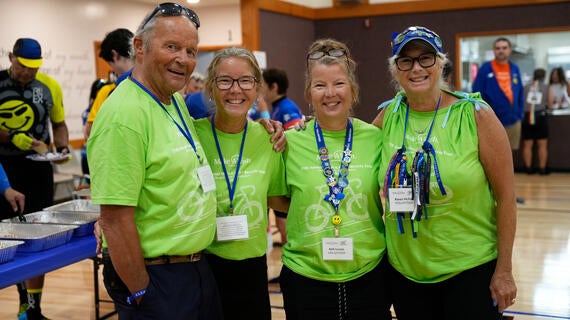 4 volunteers standing together smiling at Wish-A-Mile