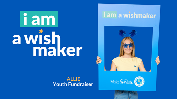 A young woman smiles through a large blue frame with the words "i am a wishmaker" at the top. She wears star-shaped blue sunglasses and blue pom-pom headbands. The background is bright blue. The text "i am a wishmaker" is also displayed in large white letters with a teal box on the left side of the image. Below the text, "ALLIE Youth Fundraiser" is written. The frame includes the "Make-A-Wish" logo and "World Wish Month April."