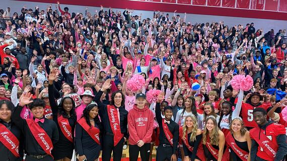 Students raising hands at pep rally