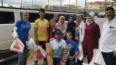 Sarah with wish kid Hajar and family holding her bags from her shopping spree