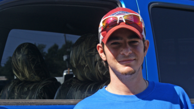 Michael smiles in front of his new truck.
