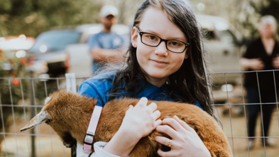 Madison hugs her one of her new pet goats, Mina