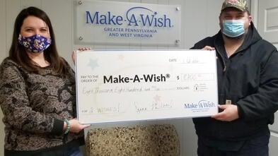 Volunteers Diana and Doug Blood generously present their donation from their Cans for Wishes fundraising event. 