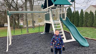 Sebastian standing with his playset 