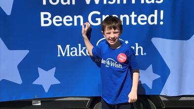 Britton stands in front of his camper on his wish reveal day.