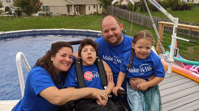 Owen and his family take a picture in front of their new above ground pool.