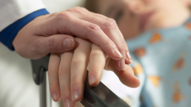 Doctor holding child's hand
