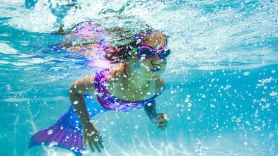 Wish kid Maggie swimming underwater